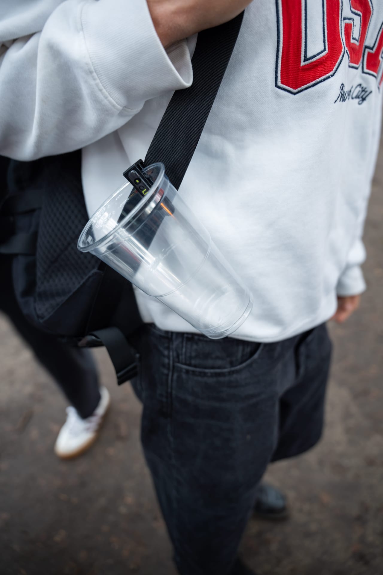 Black Mr Clipr with a cup on a bag, hands free