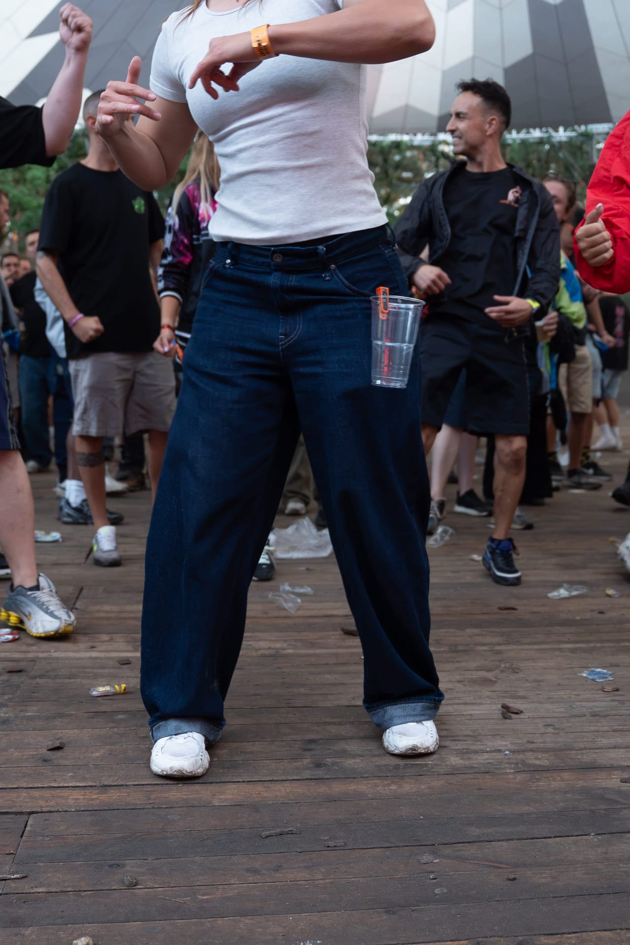 Dancing festival-goer with a cup clipped to his jeans